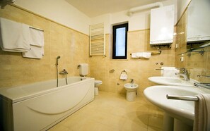 A bathroom with a bathtub, toilet, bidet, and two sinks. - Apartments Sinisa (Rovinj)