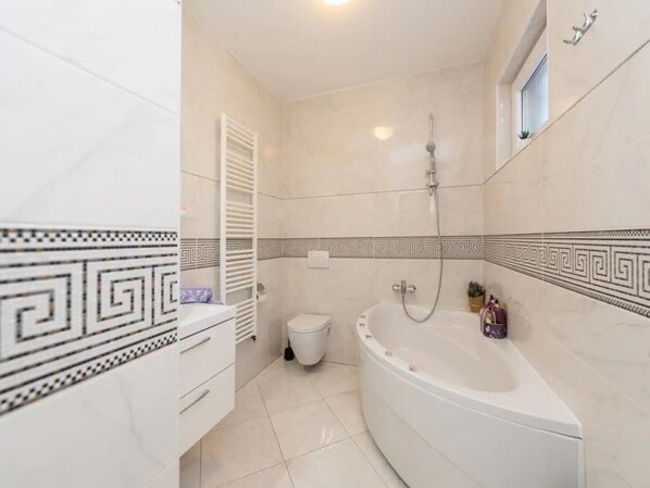 Une salle de bain avec une baignoire, des toilettes et une douche.