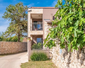 A two-story stone building with a balcony on the upper floor. - House Ruza (Privlaka)