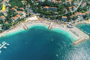 An aerial view of a coastal town with a beach, boats, and buildings. - Apartment Sabrina (Crikvenica)