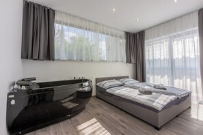 Un dormitorio moderno con cama, tocador con espejo y ventana con cortinas.