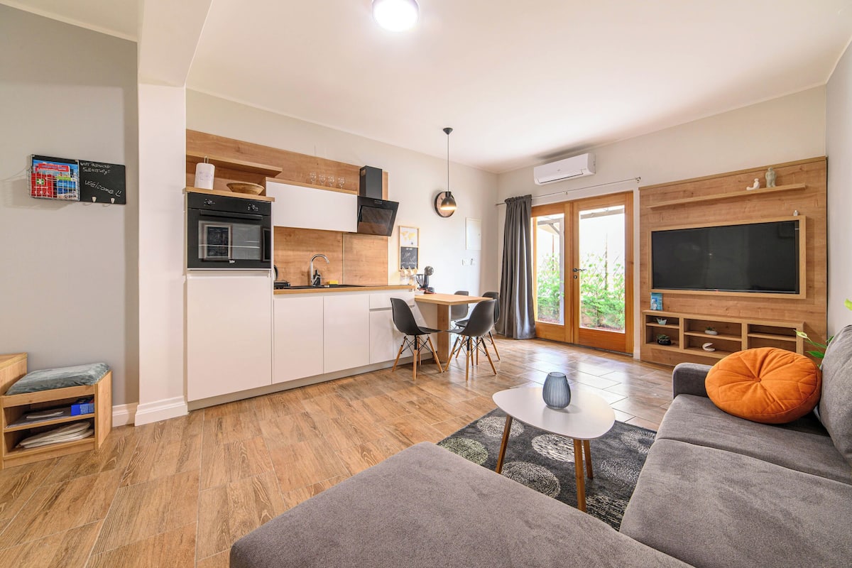 A modern apartment with a kitchen, dining area, and living room.