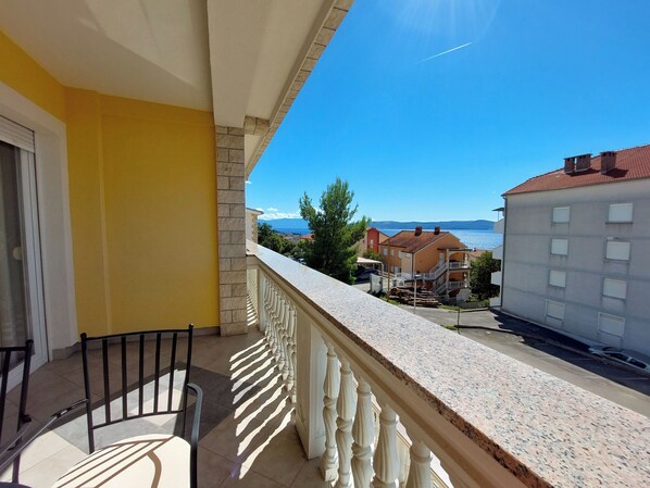 Un balcon avec vue sur la mer et les bâtiments.