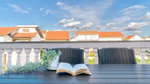 Un balcone con un tavolo, un libro e una pianta in vaso.