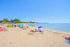 A beach with tents, umbrellas, and people relaxing. - House Neptunia (Medulin)