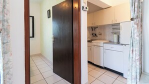 Una cucina con mobili bianchi, un fornello e un frigorifero.