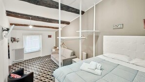 Un dormitorio moderno con una cama grande, una silla colgante y una mesita.