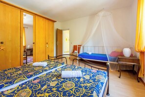 Ein Hotelzimmer mit zwei Betten, einem Holzschrank, einem Nachttisch und einem Himmelbett.