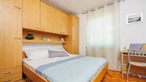 Une chambre à coucher avec un lit en bois, un bureau et une chaise.