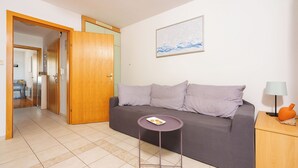 Un salon avec un canapé, une petite table ronde et une lampe.