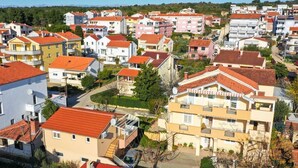 Egy lakóövezet, melyben többemeletes épületek, erkélyek és vörös cseréptetős házak találhatók.