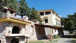 A two-story building with a stone facade and a yellow roof. - Apartment Andrea (Novi Vinodolski)