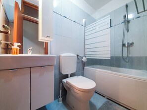 A modern bathroom with a toilet, sink, and shower. - Apartment Frano (Crikvenica)