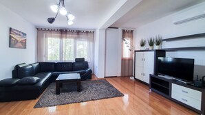 A living room with a black leather sofa, a coffee table, a flat-screen TV, and a cabinet. - Apartment Frano (Crikvenica)