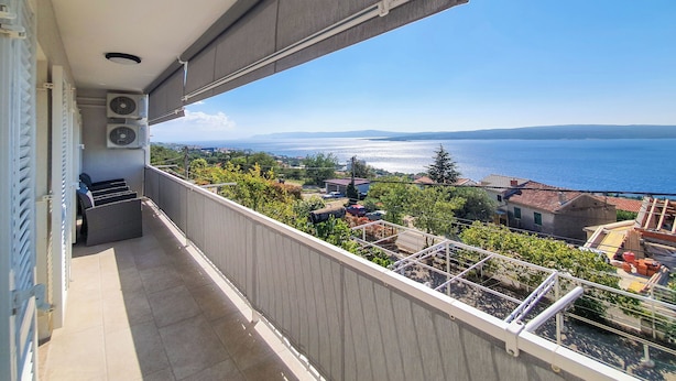 A balcony with a view of the sea and a distant shoreline. - Apartment Frano (Crikvenica)