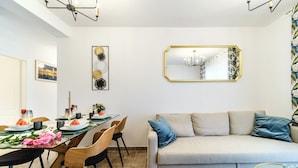 Een eetgedeelte met een lange tafel, stoelen en een bank.