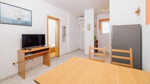 Eine moderne Küche mit einem Holztisch, einem eingebauten Ofen und einem Kühlschrank.