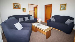 A living room with two dark sofas, a coffee table, and framed pictures on the walls. - Apartments Vesna (Novi Vinodolski)