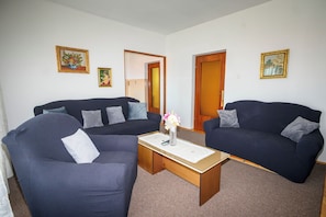 A living room with two dark sofas, a coffee table, and framed pictures on the walls. - Apartments Vesna (Novi Vinodolski)