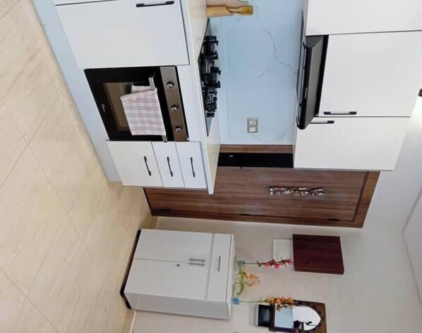 A compact kitchen with white cabinets, a microwave, and a small countertop. - 🏖️ Furnished studio with sea view - comfort & charm (Kénitra)