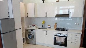 Cocina compacta con lavadora, horno y lavaplatos.