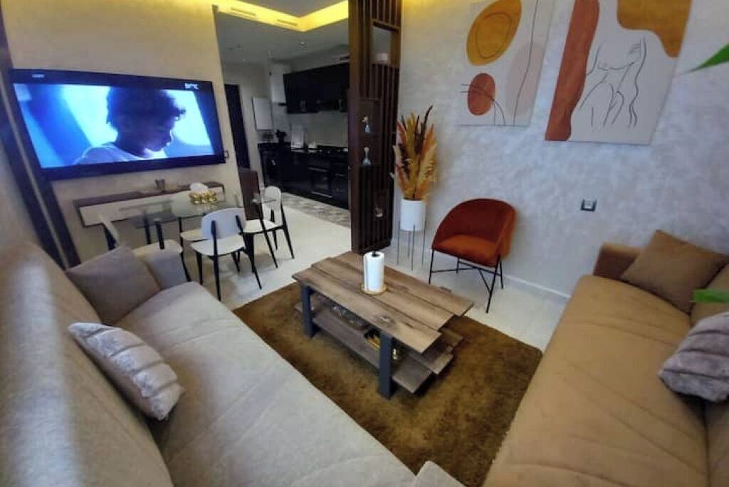 Uma sala de estar moderna com um sofá, uma mesa de centro e uma televisão.