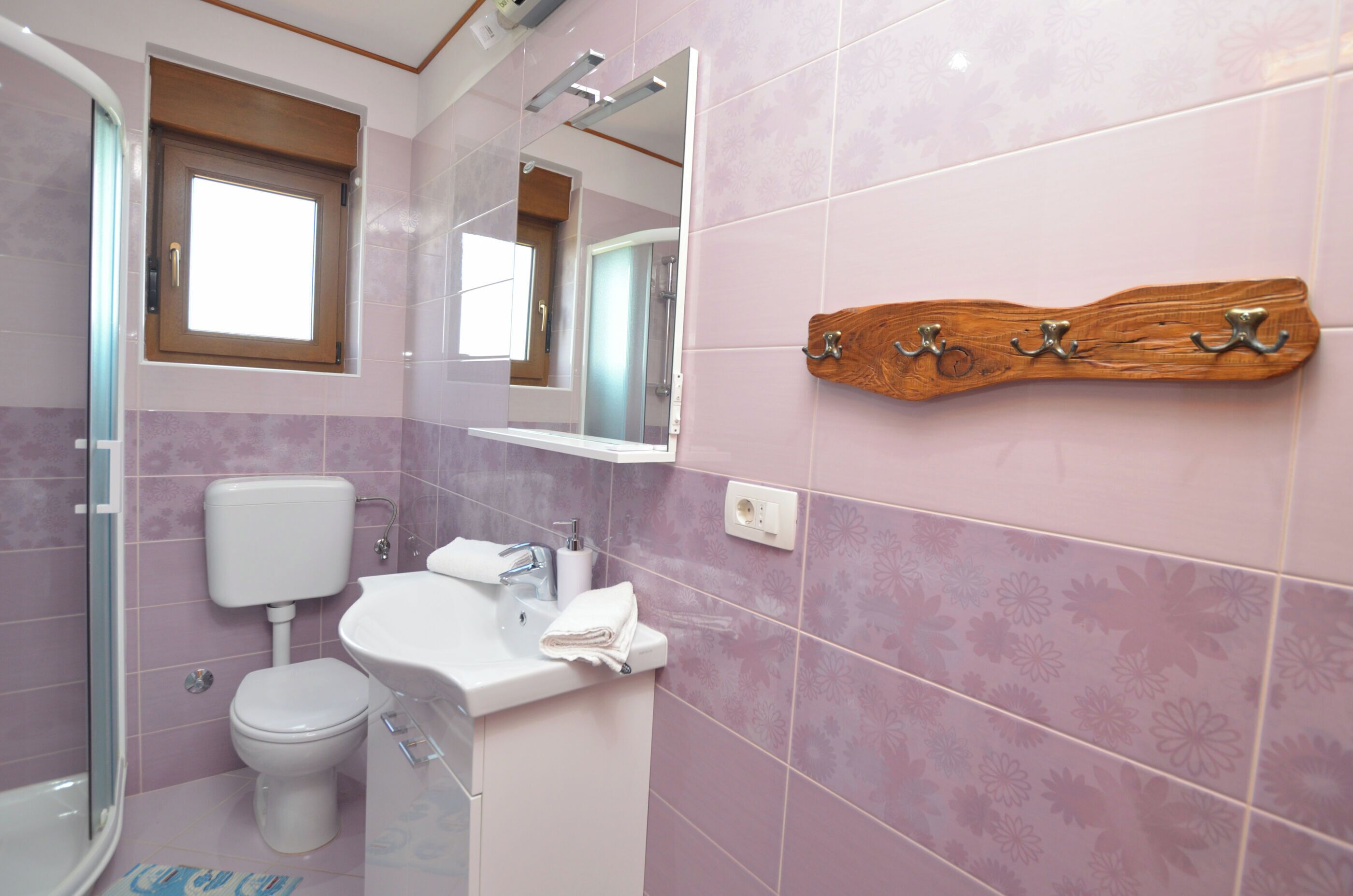 A bathroom with a toilet, sink, and shower.