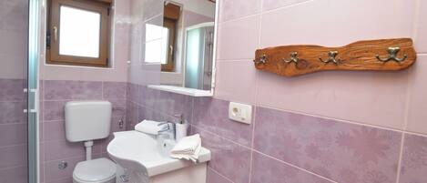 A bathroom with a toilet, sink, and shower.