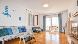 En moderne stue med sofa, sofabord og spiseplads med bord og stole.