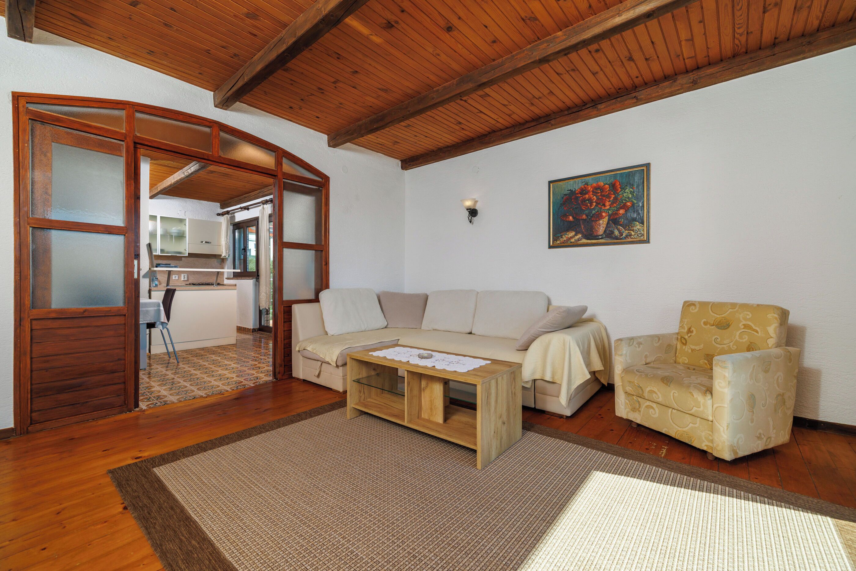 A living room with a wooden ceiling, a sofa, a chair, and a coffee table.