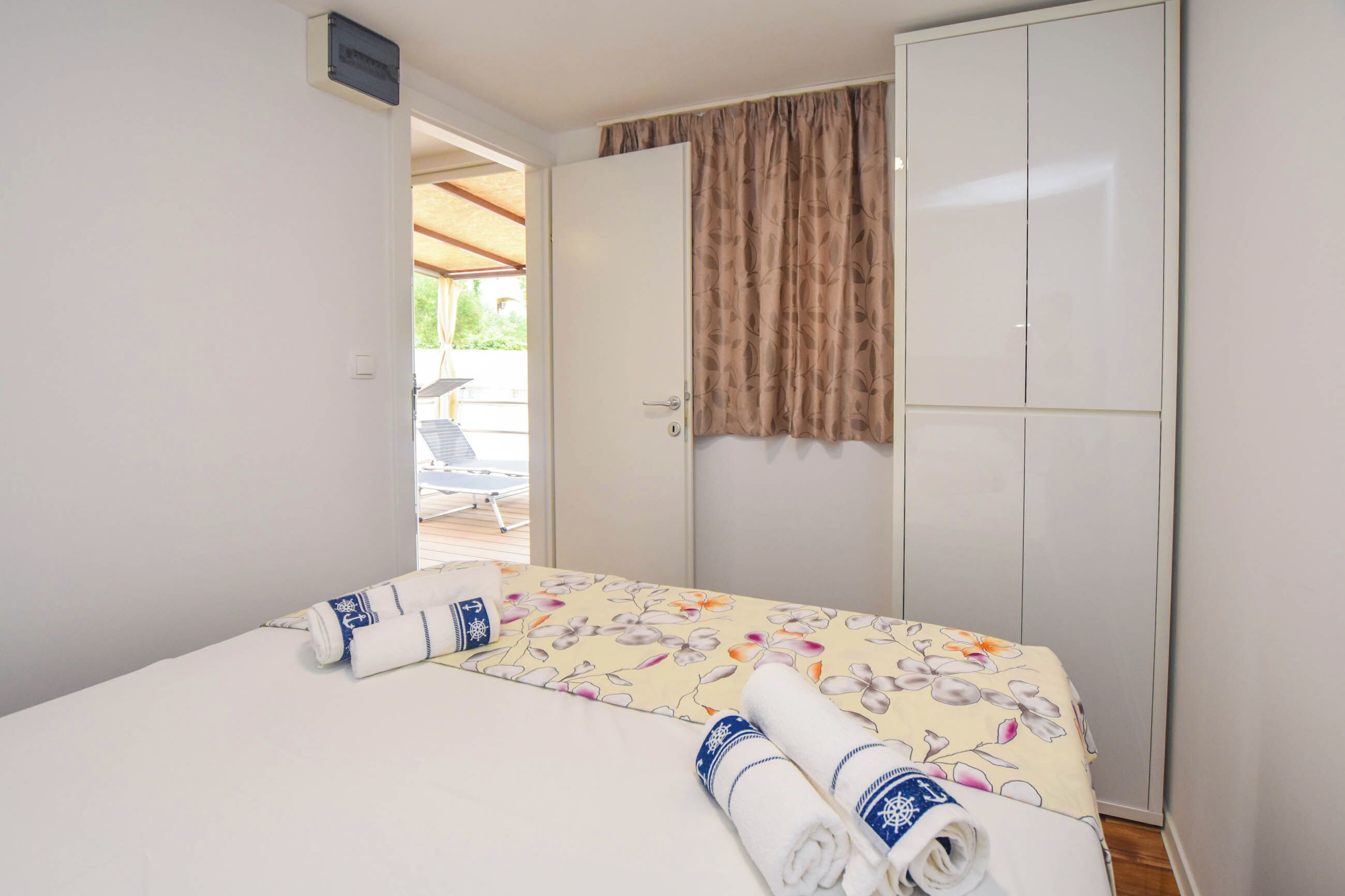 Une chambre d’hôtel comprenant un lit, une armoire et une porte donnant sur un espace extérieur.