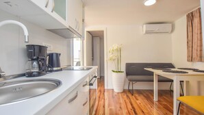 A modern kitchen with a sink, coffee maker, and a dining area with a table and chairs. - Mobile Home Dandelion (Biograd na Moru)