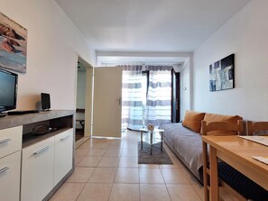 Ein gemütlicher Wohnbereich mit Küchenzeile, Essplatz und einer Couch.