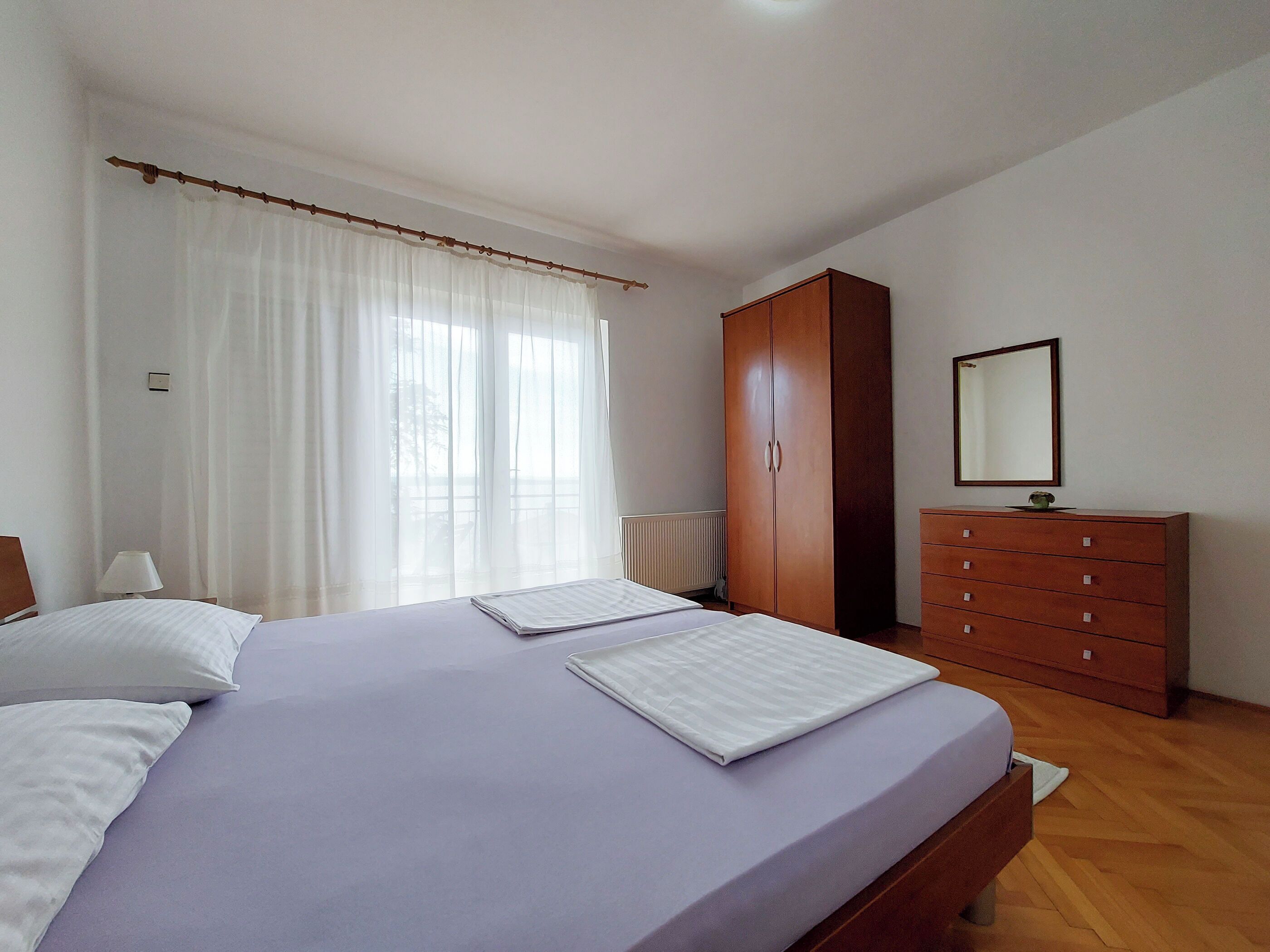 Une chambre à coucher avec un lit, une armoire et un miroir.