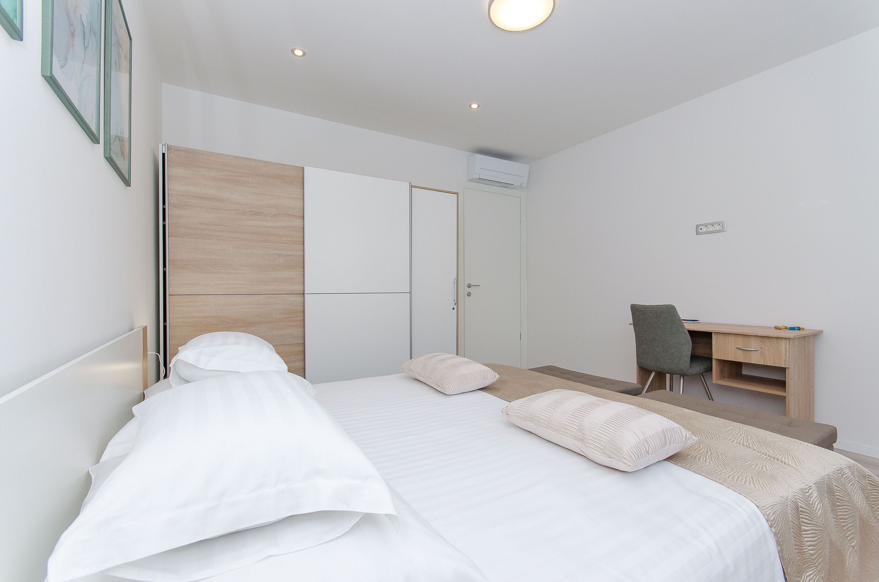 Un dormitorio con una cama, un escritorio y una silla.