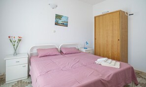 A bedroom with a bed, nightstand, dresser, and a wooden wardrobe. - Apartments Villa Sunset (Vodice)