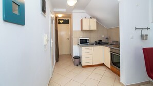 Eine kleine Küche mit Mikrowelle, Backofen und Schränken.