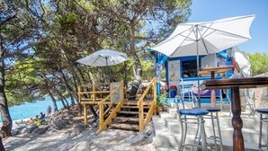 Eine Strandbar mit Außenbereich und einer Treppe zu einer Holzterrasse.