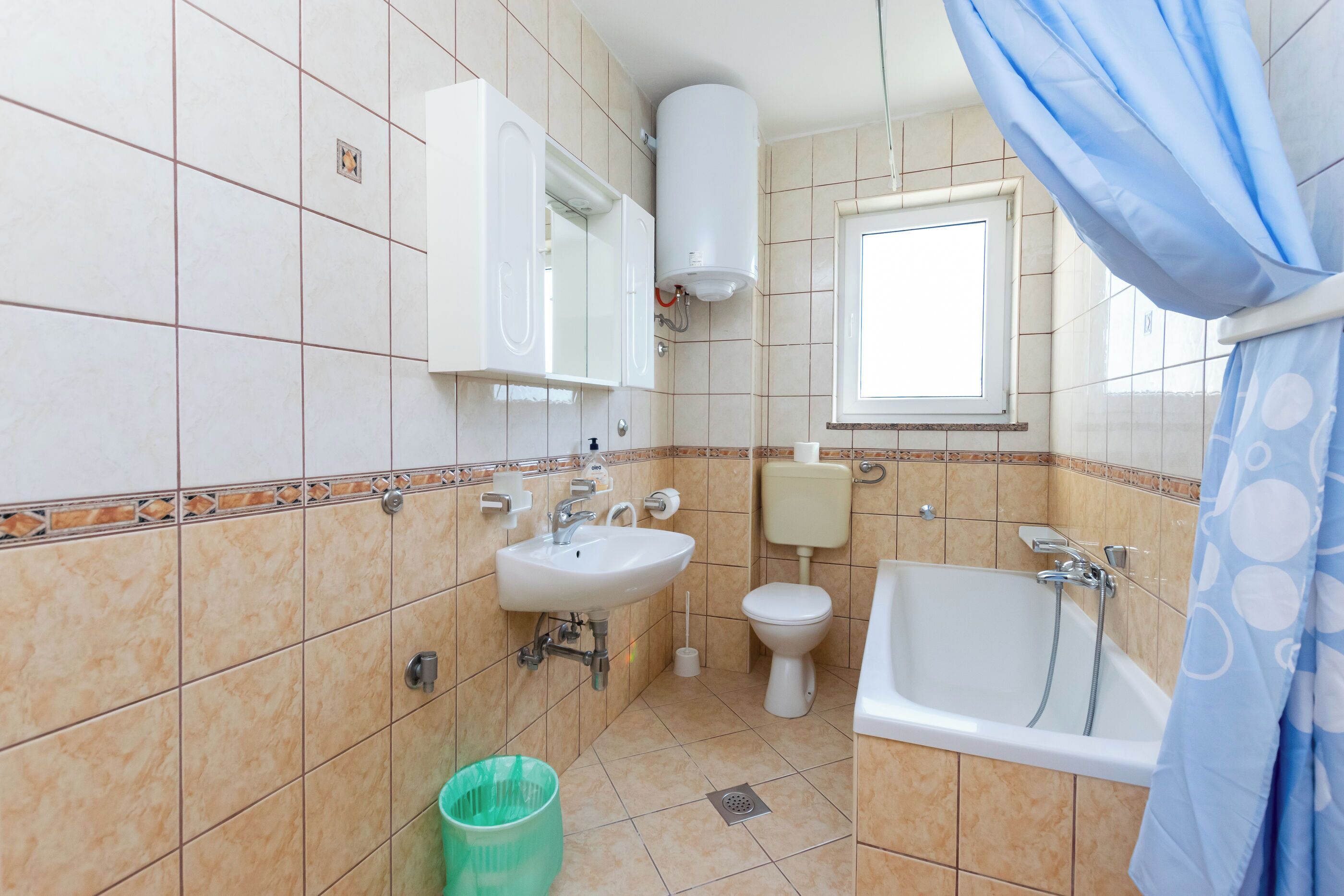 A bathroom with a sink, toilet, and bathtub.