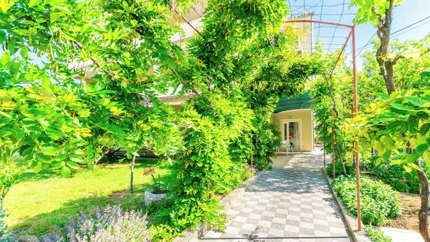 A garden pathway with checkered paving leading to a building entrance. - Apartments Ivan i Marija (Lopar)