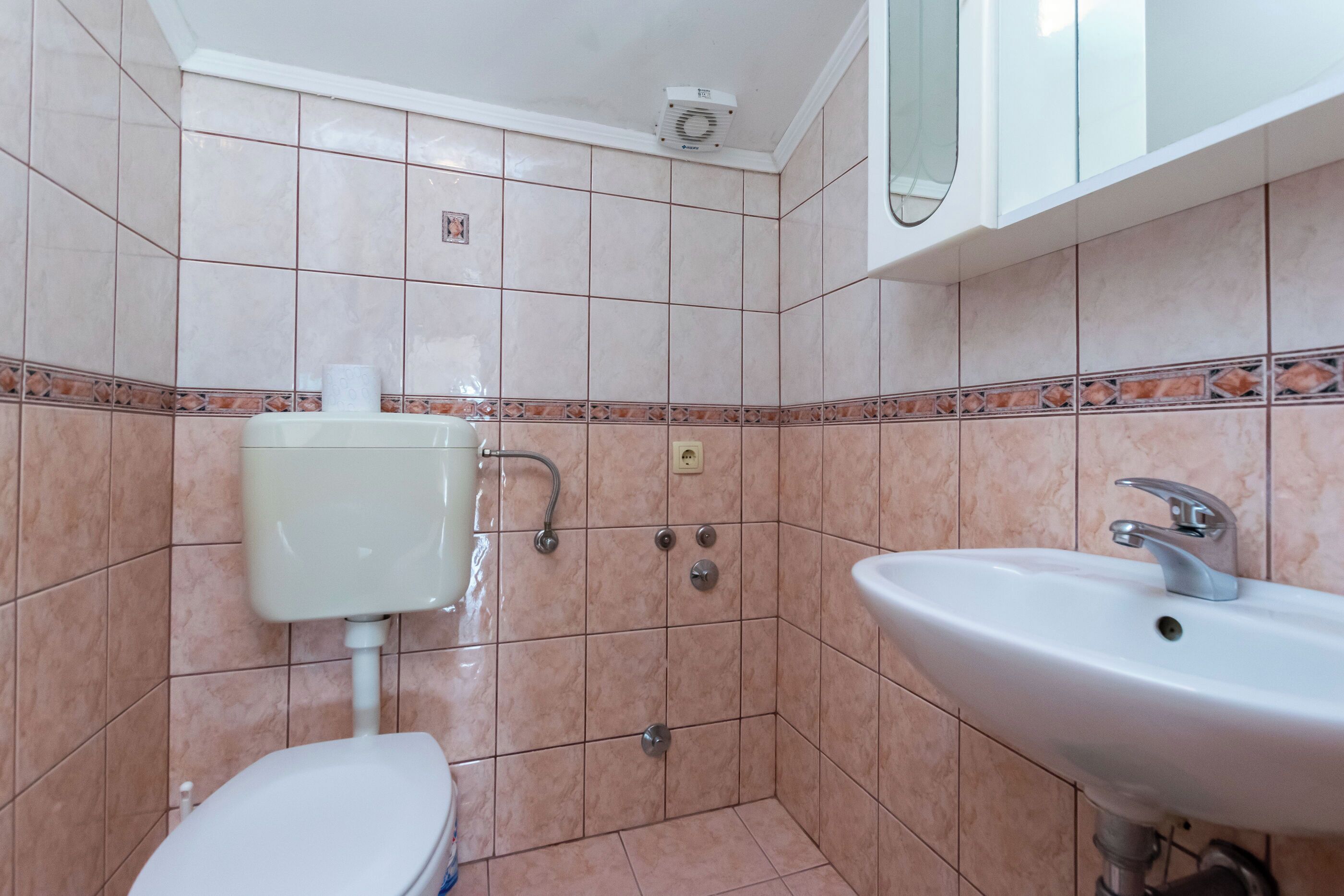A bathroom with a toilet, sink, and shower.