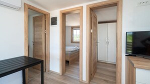 A modern room with a bed, a TV, and a desk. - Mobile Home Banovi Dvori III (Tisno)