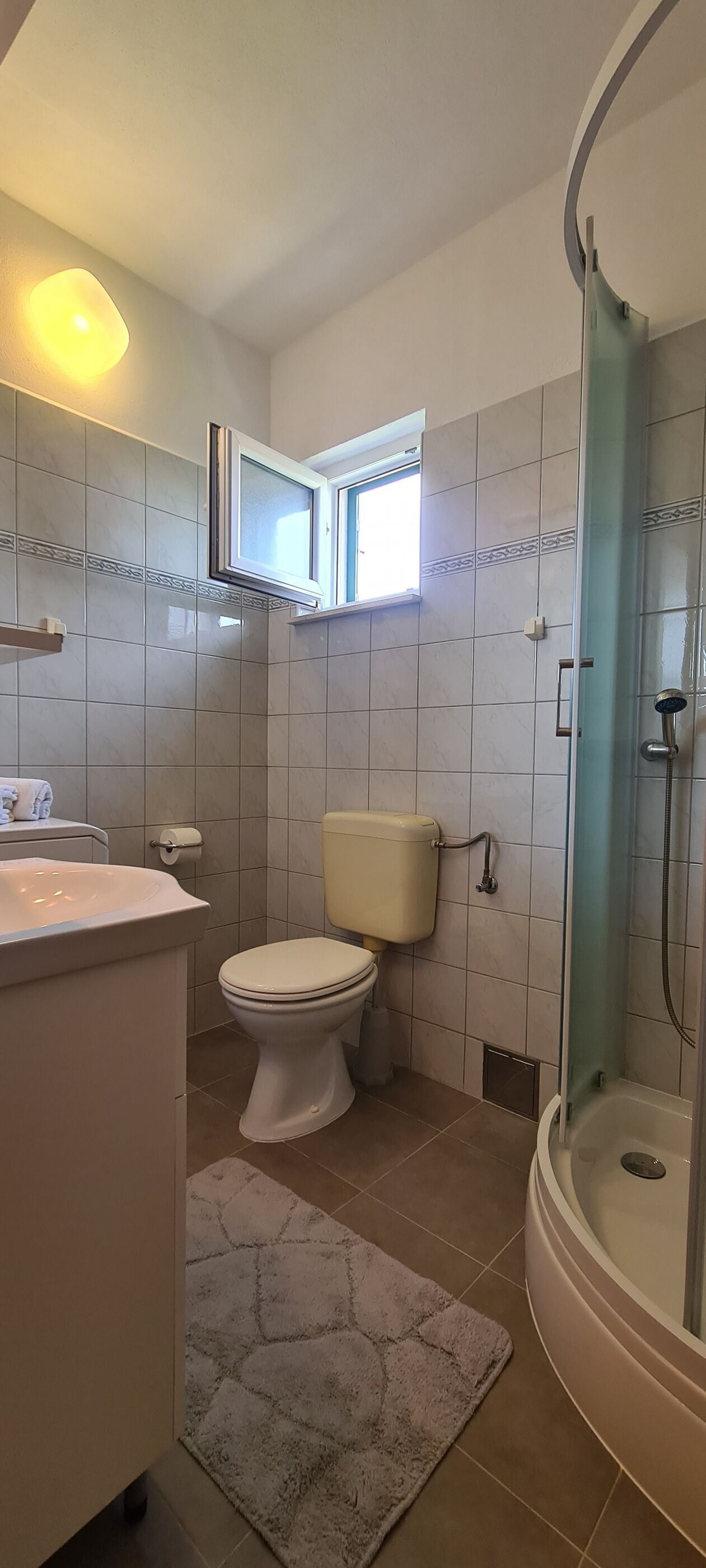 A bathroom with a toilet, sink, and shower.