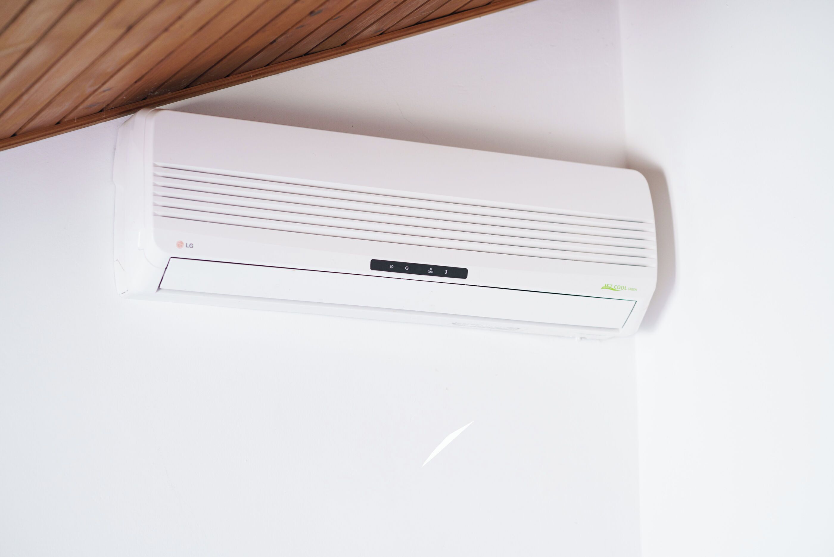 Ar-condicionado LG branco fixado em uma parede branca.
