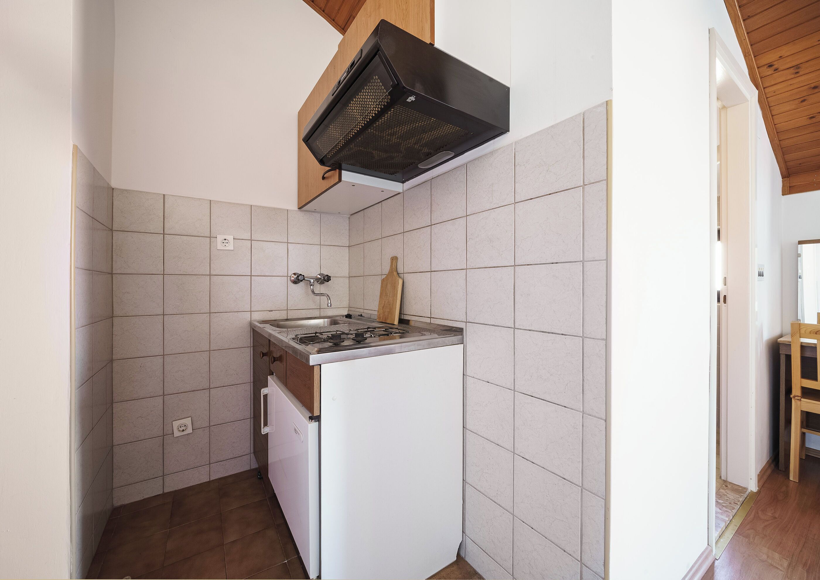 A compact kitchen with a gas stove, a built-in oven, and a microwave.