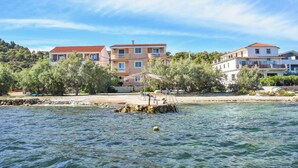 A coastal building with a red roof, a balcony, and a view of the sea. - Apartments Anita (Tkon)