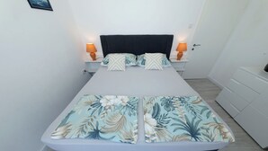 Un lit avec une couvre-lit à motifs floraux, deux lampes de chevet et une table de nuit.