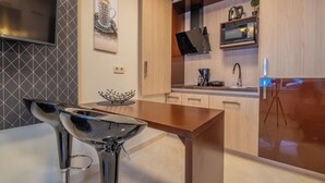 Een moderne keuken met een houten aanrecht, een ingebouwde magnetron en een roestvrijstalen spoelbak.