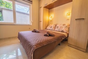 A bedroom with a bed, a window, and a wardrobe. - House Lady 1 (Novi Vinodolski)