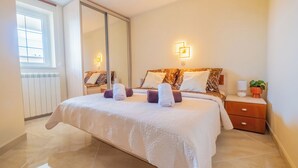 Una camera da letto con un letto grande, un comodino, uno specchio e una finestra.